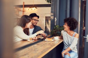 "Eating disorders". Three people share a light brunch, and laugh in conversation.