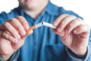 "Smoking cessation". Person snapping a cigarette in half.