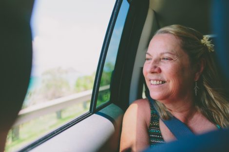 Middle-aged woman smiling whiling riding in a car, able to manage her feelings.