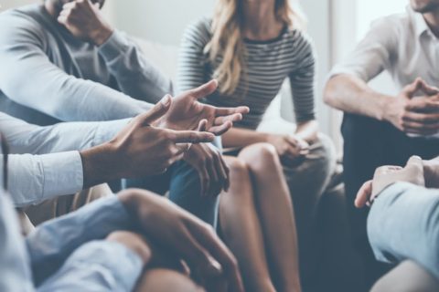 A person gestures during a group therapy session.