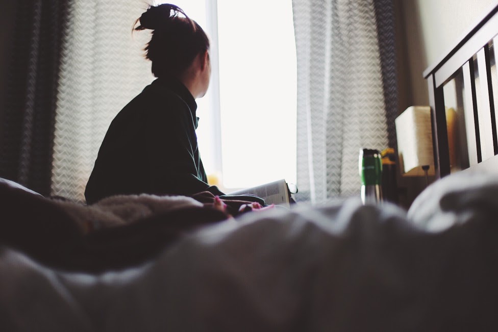 A depressed person looking out a window.