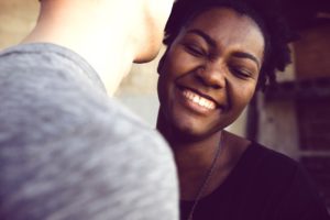"Your personal relationships can be more fulfilling." A woman closes her eyes while grinning and her partner leans closer.