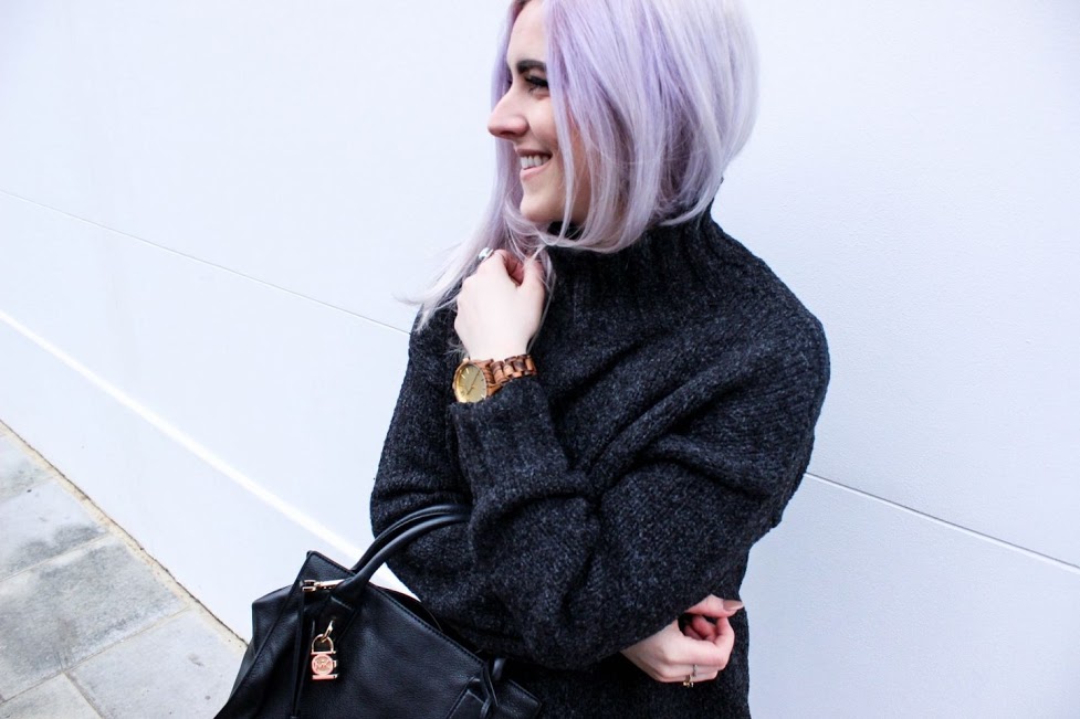 Young hip woman capable of managing her stress, smiling while outside a building.