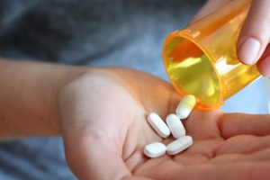 "Substance use." Close-up of someone pouring multiple pills into their hand.