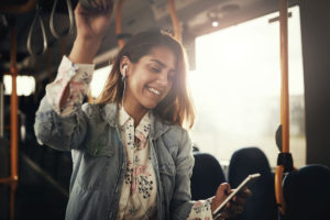 "The CBT Approach." Young woman who has benefited from CBT riding transit, smiling.